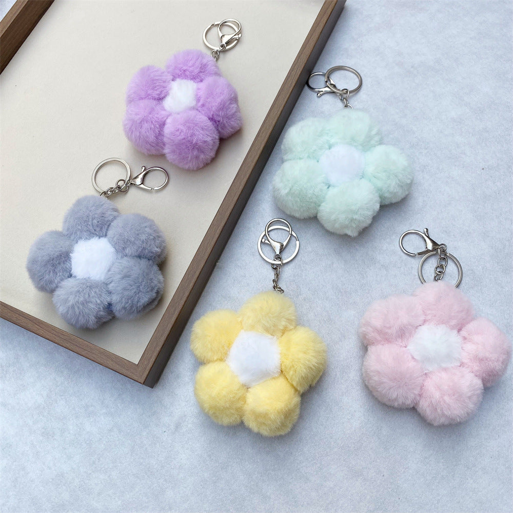 Close-up of a vibrant floral plush keychain, a soft accessory for bags and keys.