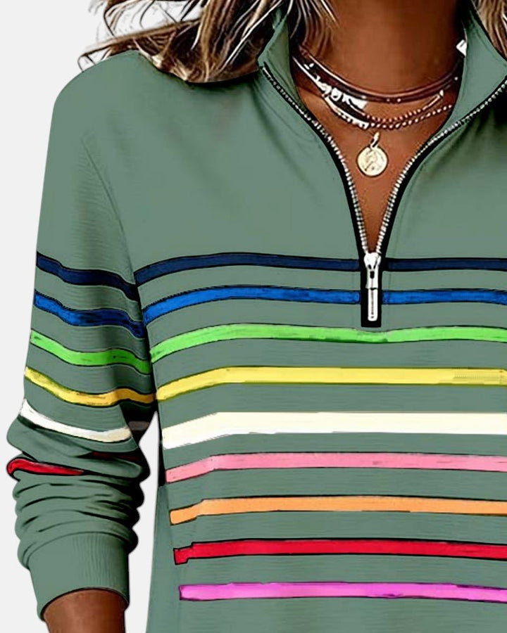Woman enjoying a cup of coffee in a casual striped long sleeve pullover.