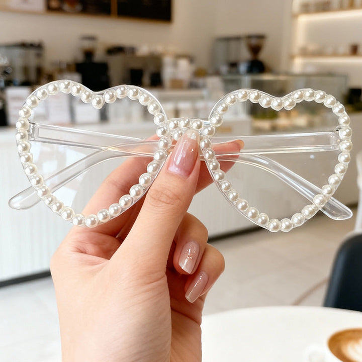 Elegant women's heart-shaped sunglasses, featuring delicate pearl embellishments.