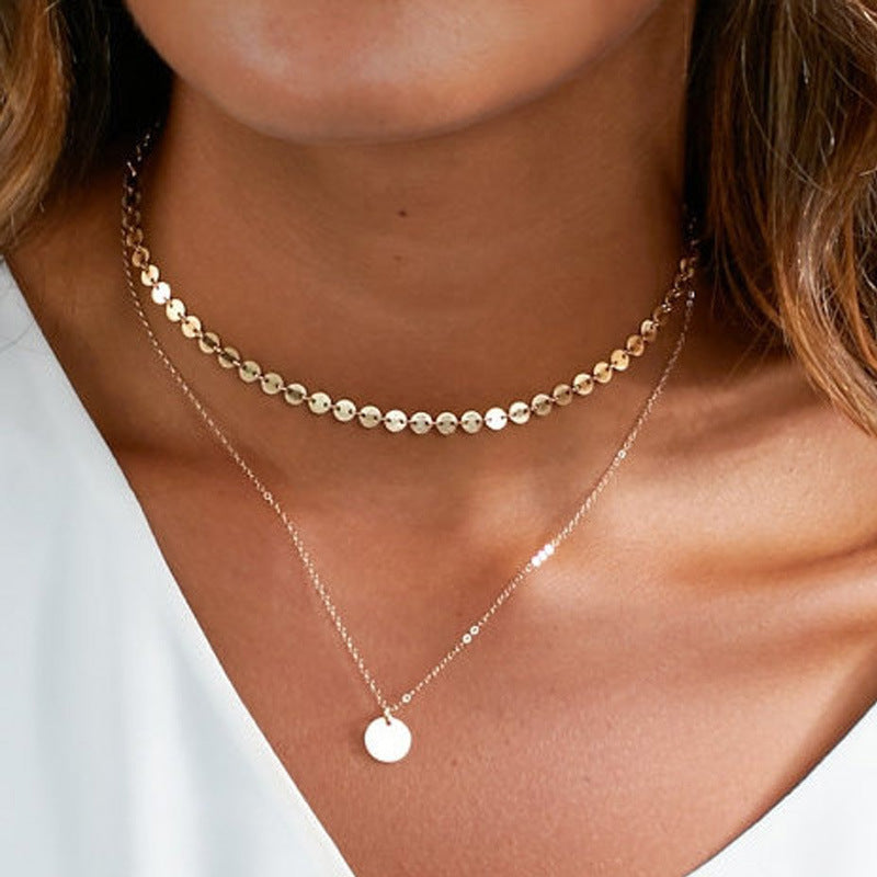 Close-up of women's layered disc chain necklace featuring both gold & silver tones, elegant fashion jewelry.