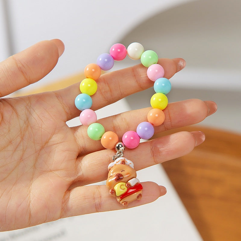 Close-up: Colorful children's charm bracelet with various plastic animal beads and bright colors.