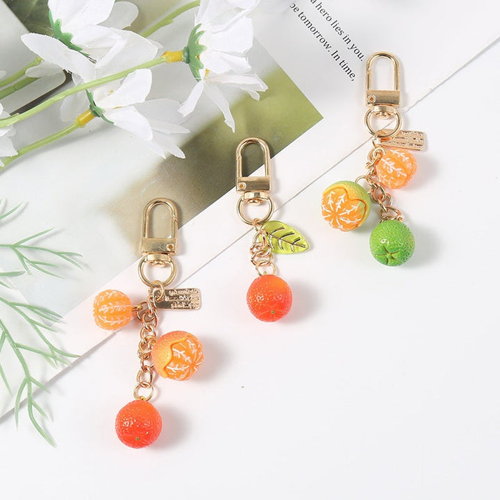 Vibrant fruit design keychain adds a pop of color to bags & keys. Durable and stylish purse accessory.