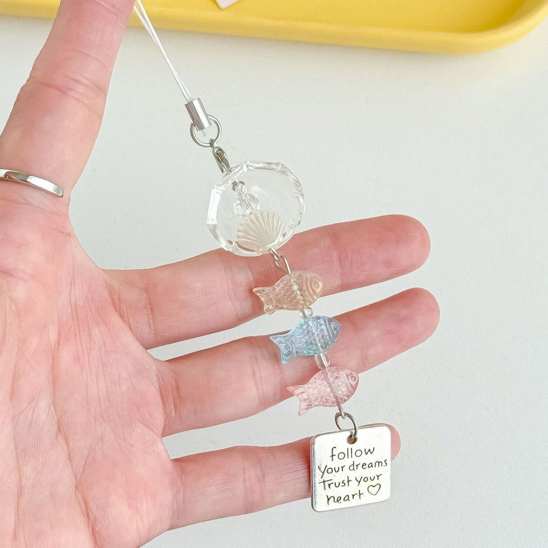 Fun ocean accessory keychain featuring a detailed fish charm and a delicate shell charm.