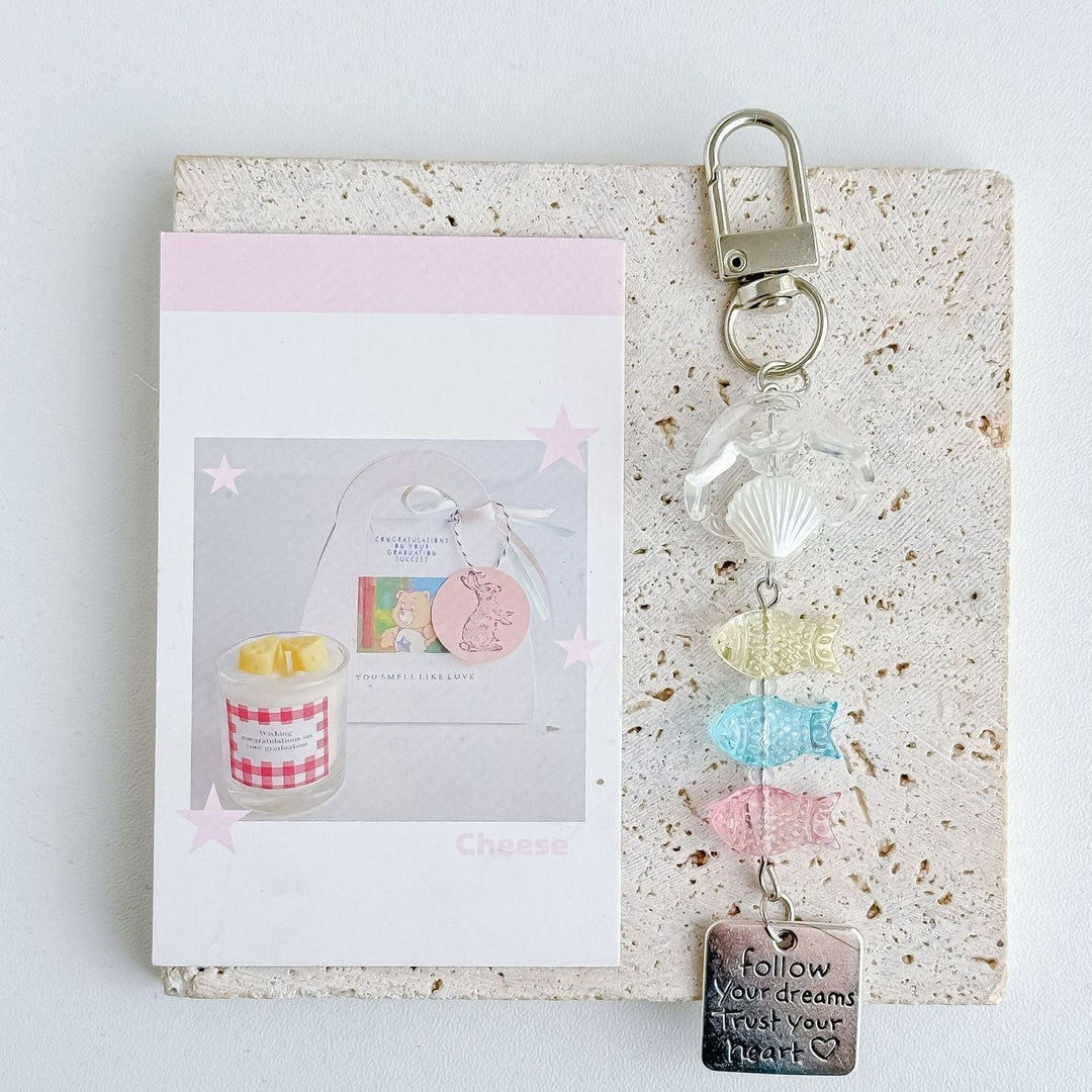Detailed plastic nautical charm keychain displaying vibrant marine fish and shell designs. Great ocean accessory.