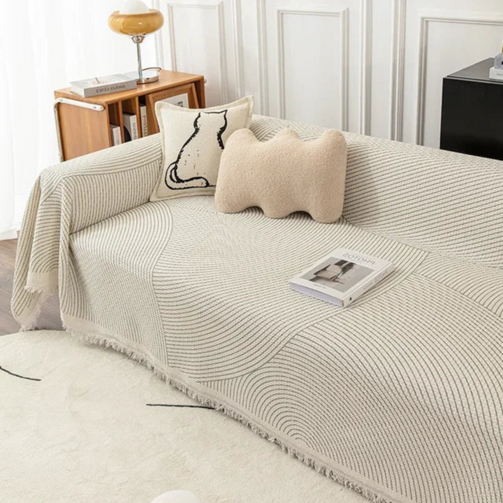 Soft, cozy Scandinavian throw blanket with tassels, perfect for snuggling on a sofa. Nordic home decor.