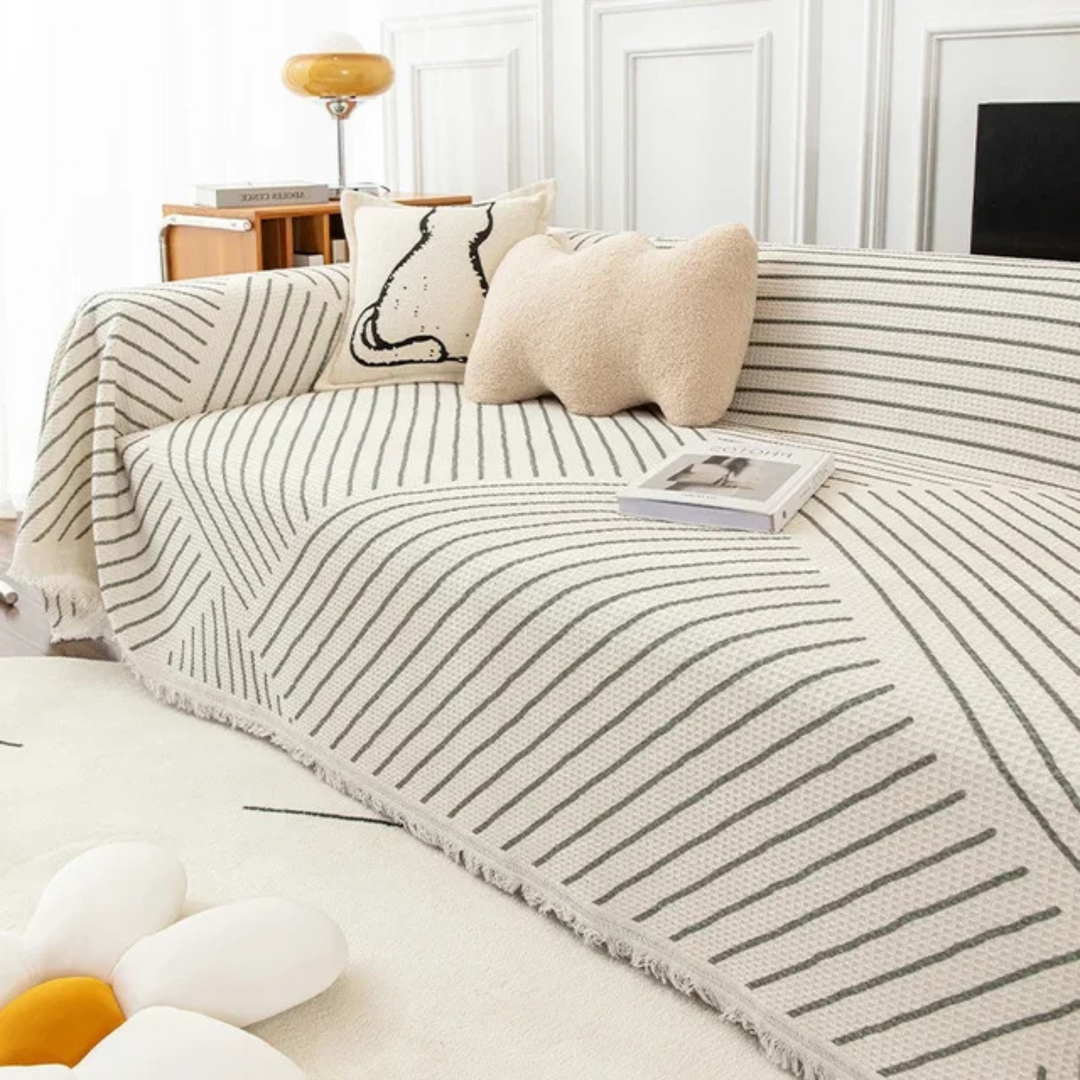 Stylish Scandinavian tassel throw blanket protecting sofa; adds cozy Nordic accent to living room decor.