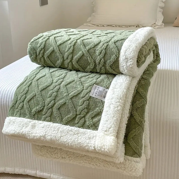 Warm Sherpa fleece blanket draped over a sofa, perfect cozy comfort for living room decor & all-season use.