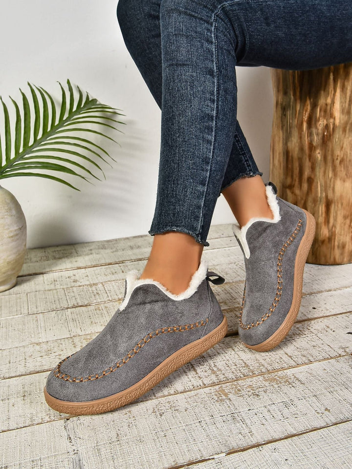 Warm women's slip-on slippers with plush interior, offering ultimate comfort and coziness for home wear.
