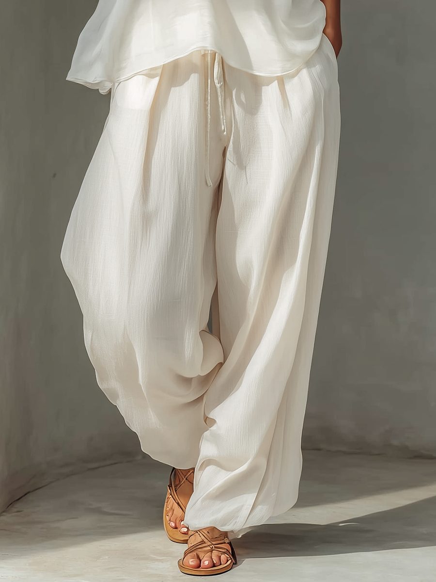 Stylish women's cream chiffon wide leg trousers set with drawstring waist. Chic and comfortable summer fashion.