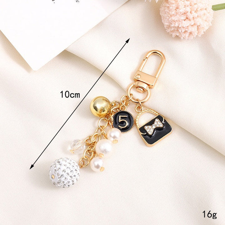 Playful bear keychain holding a heart, adorned with a sweet little bell charm for keys.