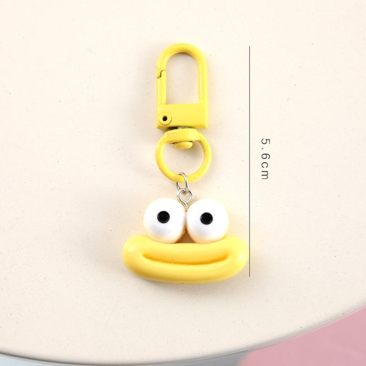 Assorted cartoon face keychains displayed, highlighting their cute designs & bright colors.