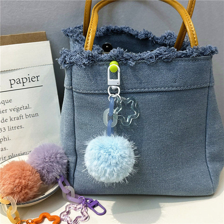 Playful women's fuzzy pom-pom keychain, a colorful and soft bag accessory.