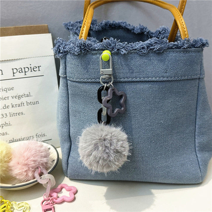 Fuzzy pom-pom keychain for women's bags. Cute, soft, and vibrant accessory.