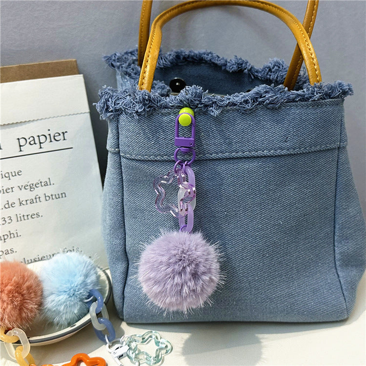 Women's fuzzy pom-pom keychain. Adorable bag charm accessory for a playful touch.