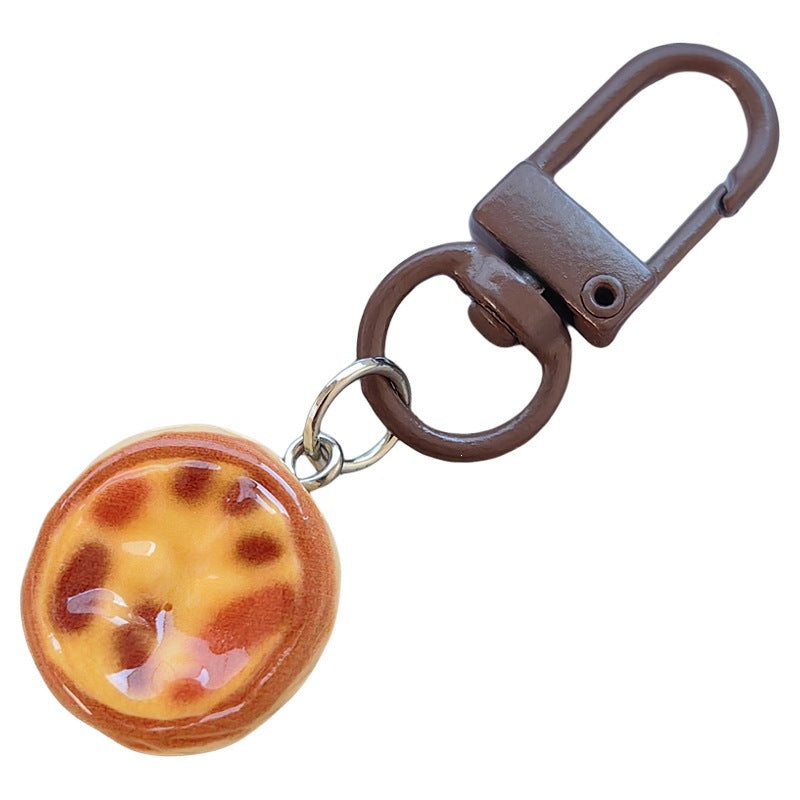 Detailed miniature cake keychain featuring chocolate layers & frosting. A unique, cute dessert bag charm.