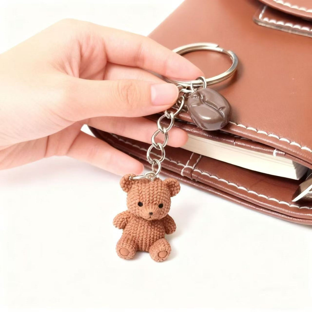 Adorable bear and drink bag charm. Cute keychain accessory, ideal for keys or backpacks. Playful design.
