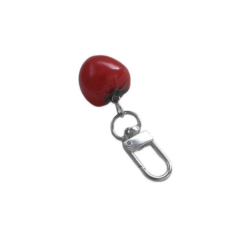 Distinctive tomato-shaped plastic keychain, a playful and eye-catching bag accessory.
