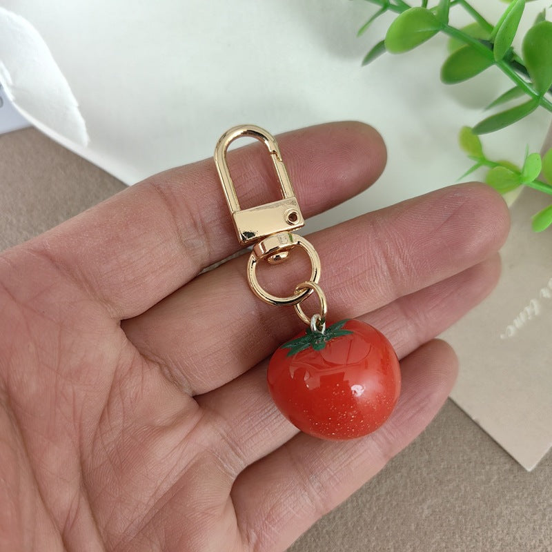 Bright red plastic tomato keychain, a durable and cute accessory for bags, keys, or gifts.
