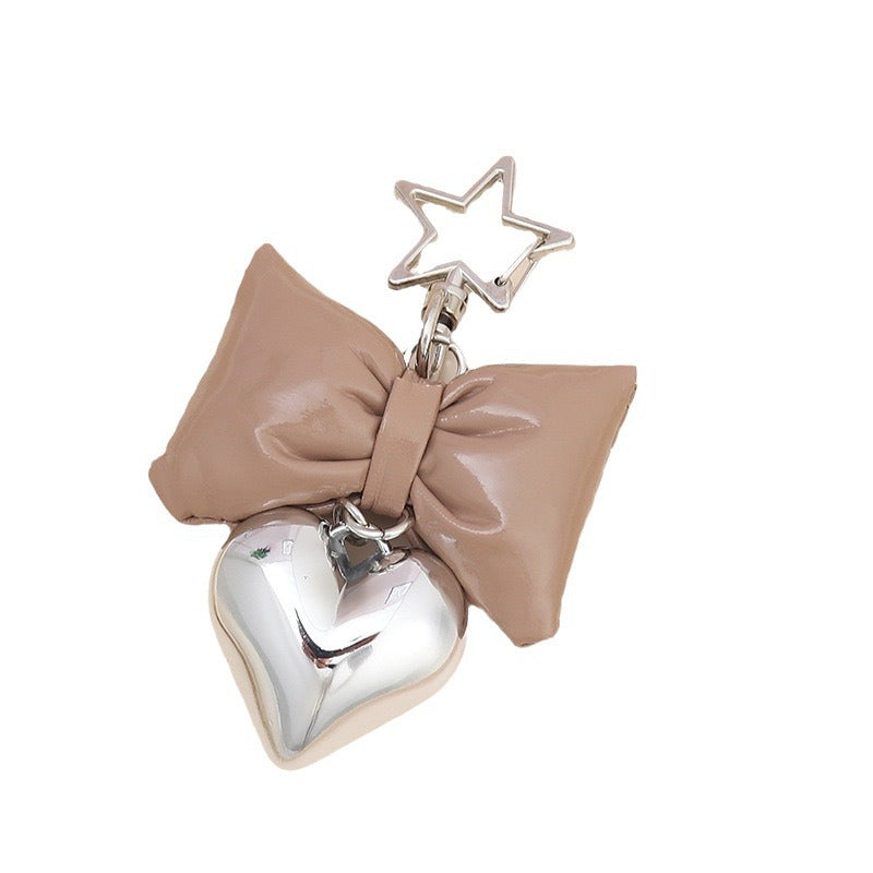Trendy women's bag charm & key holder featuring a cute bow and heart. Stylish purse accessory.