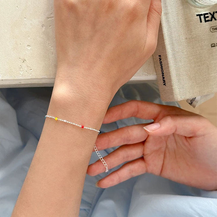 Elegant gold-tone chain bracelet with delicate multi-colored beads, a dainty women's accessory.
