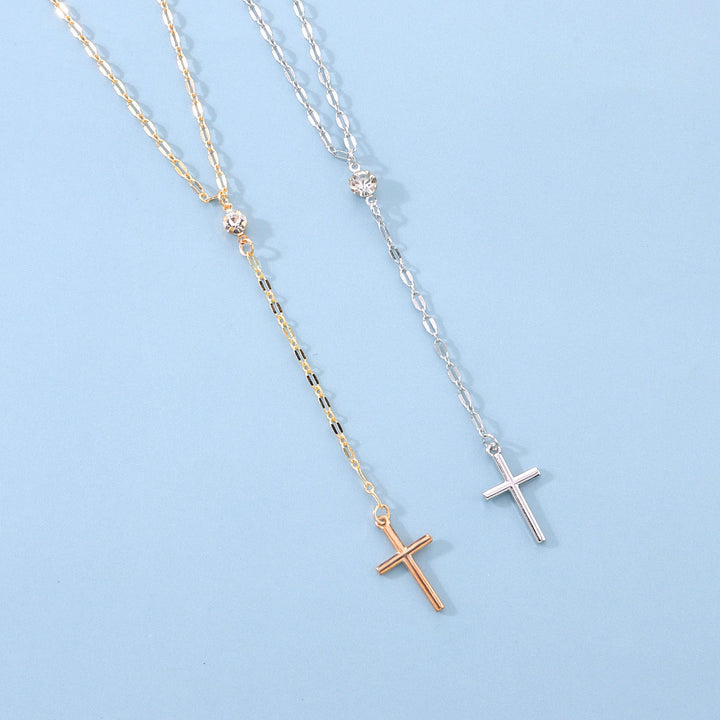 Delicate women's lariat necklace with a small cross, elegant spiritual fashion accessory.