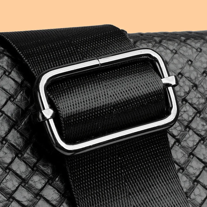 Close-up of rich, full-grain men's premium leather crossbody bag material.