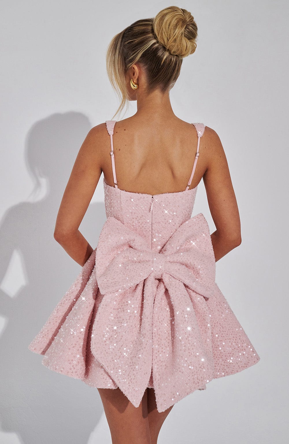 Shimmering sequin mini dress with an elegant bow detail. A dazzling choice for women's evening wear parties.