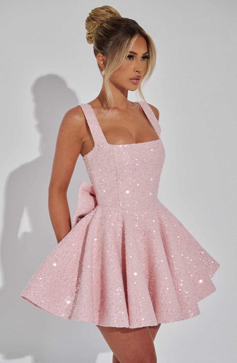 Stylish sleeveless mini dress featuring a prominent bow and dazzling sequins. Ideal women's party fashion.