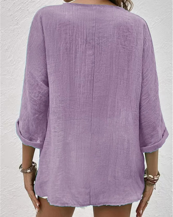 Lightweight women's v-neck button-down blouse with rolled sleeves, ideal for versatile summer fashion.