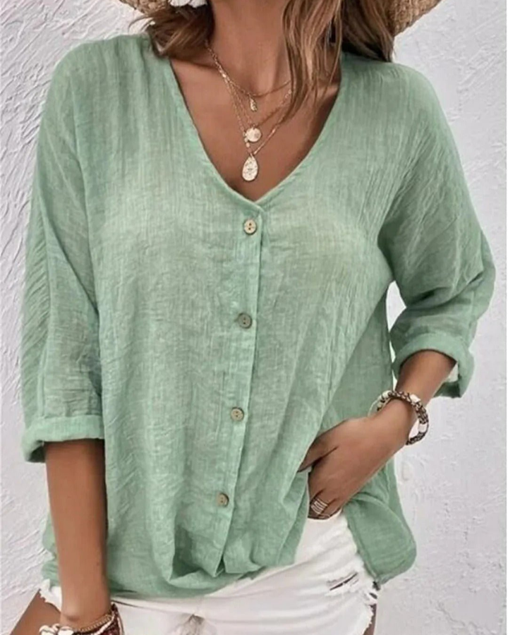 Casual women's blouse: deep v-neck, button-front, rolled sleeves. A chic everyday top for warm weather.