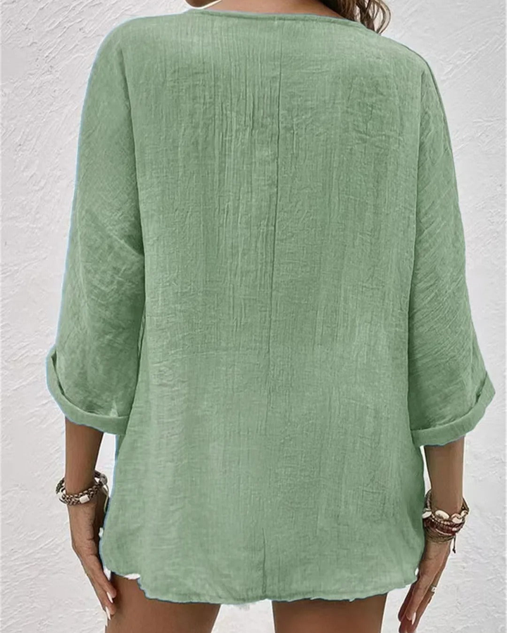 Elegant women's deep v-neck blouse, button-down design & rolled sleeves. Versatile for office or casual.