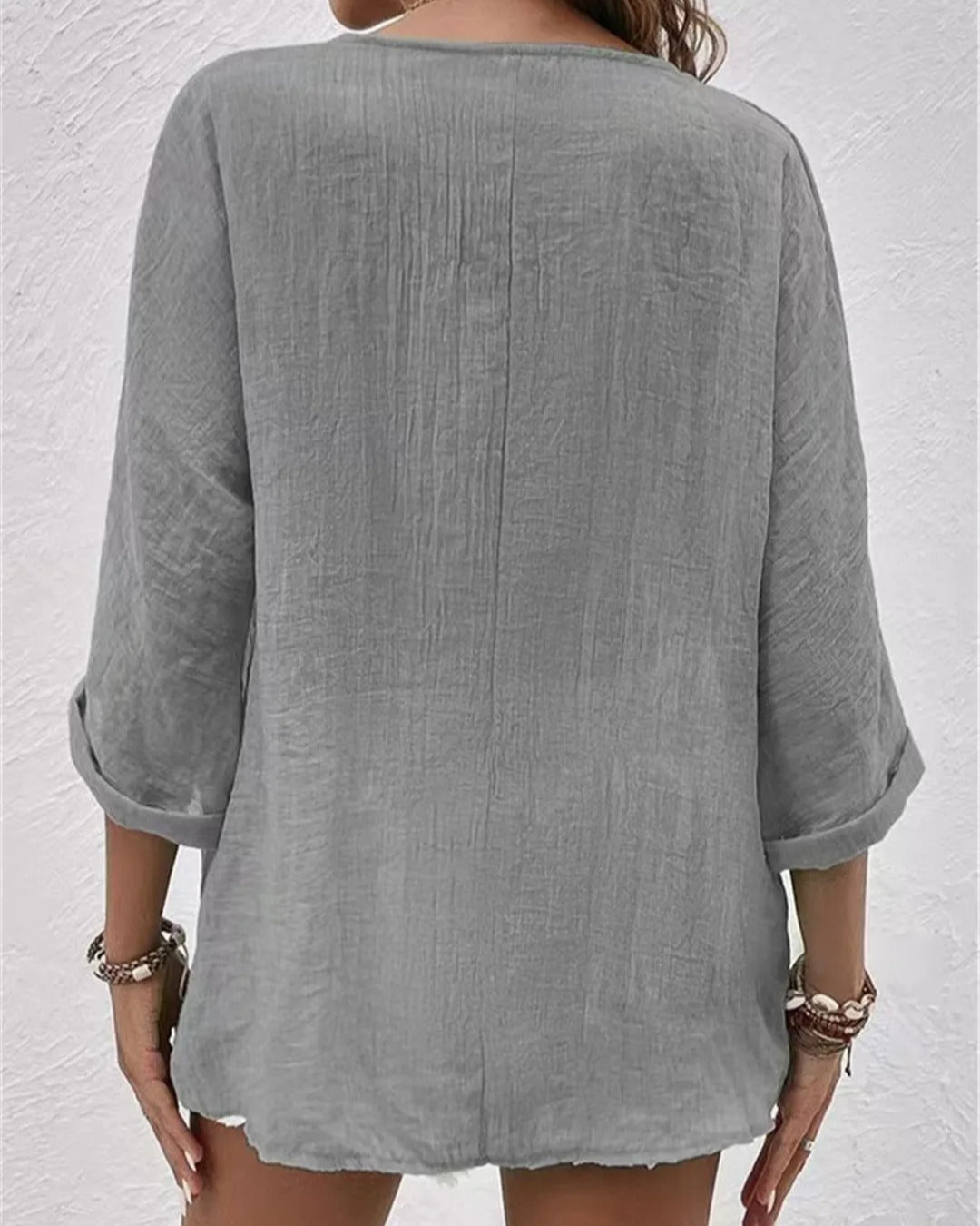 Chic women's button-down shirt with a deep v-neck and rolled sleeves, great for everyday fashion.
