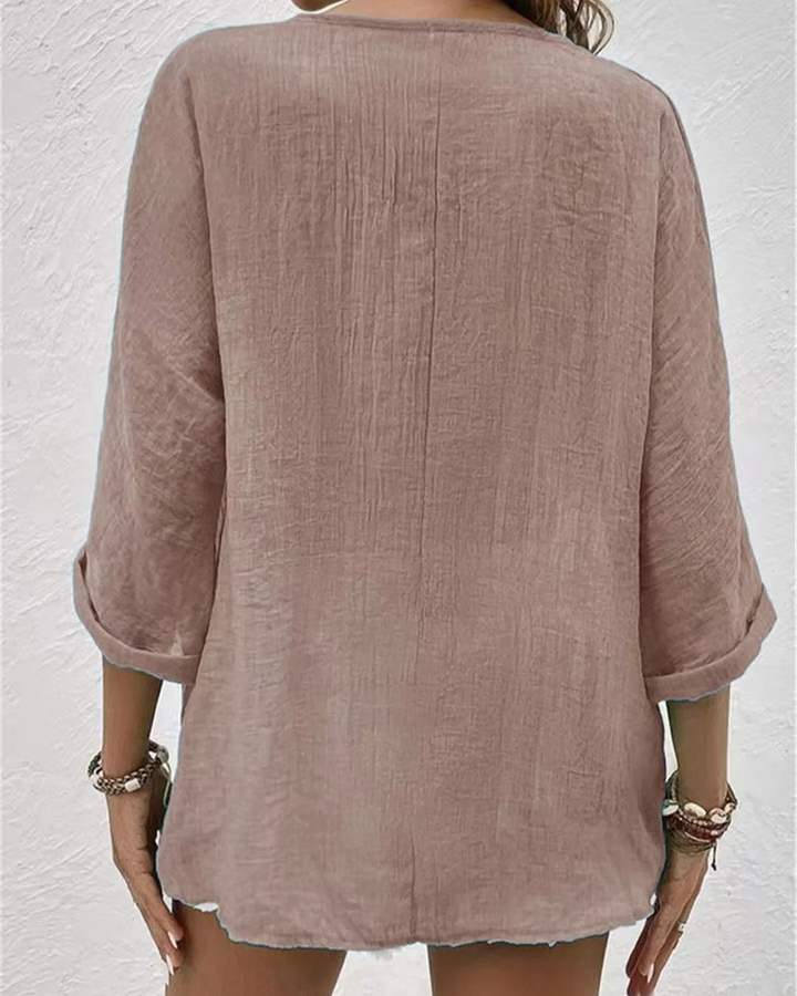Stylish women's deep v-neck blouse, features a button-down front and rolled sleeves for a modern look.
