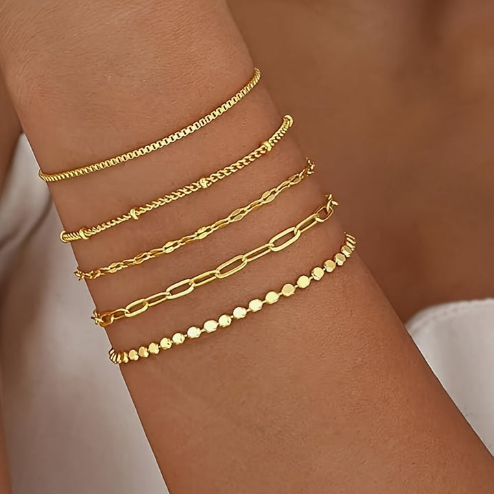 Layered gold chain bracelets, delicate women's fashion accessory. Adjustable & elegant jewelry.
