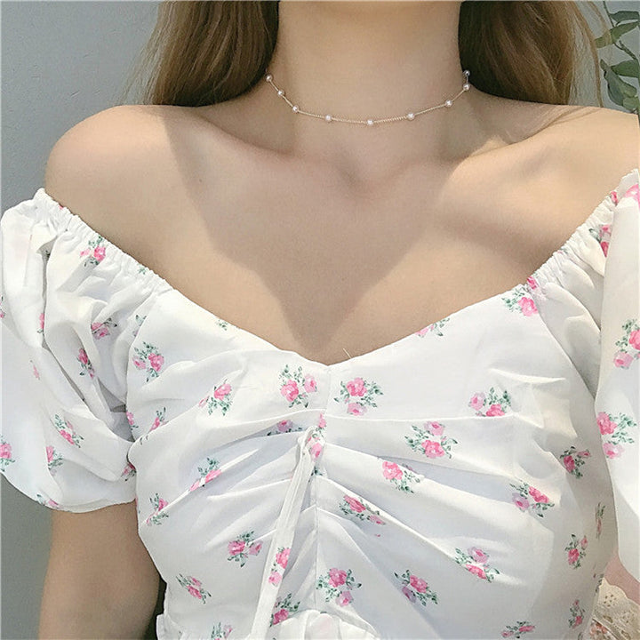 Delicate women's gold chain necklace with a single white pearl accent, perfect elegant jewelry.