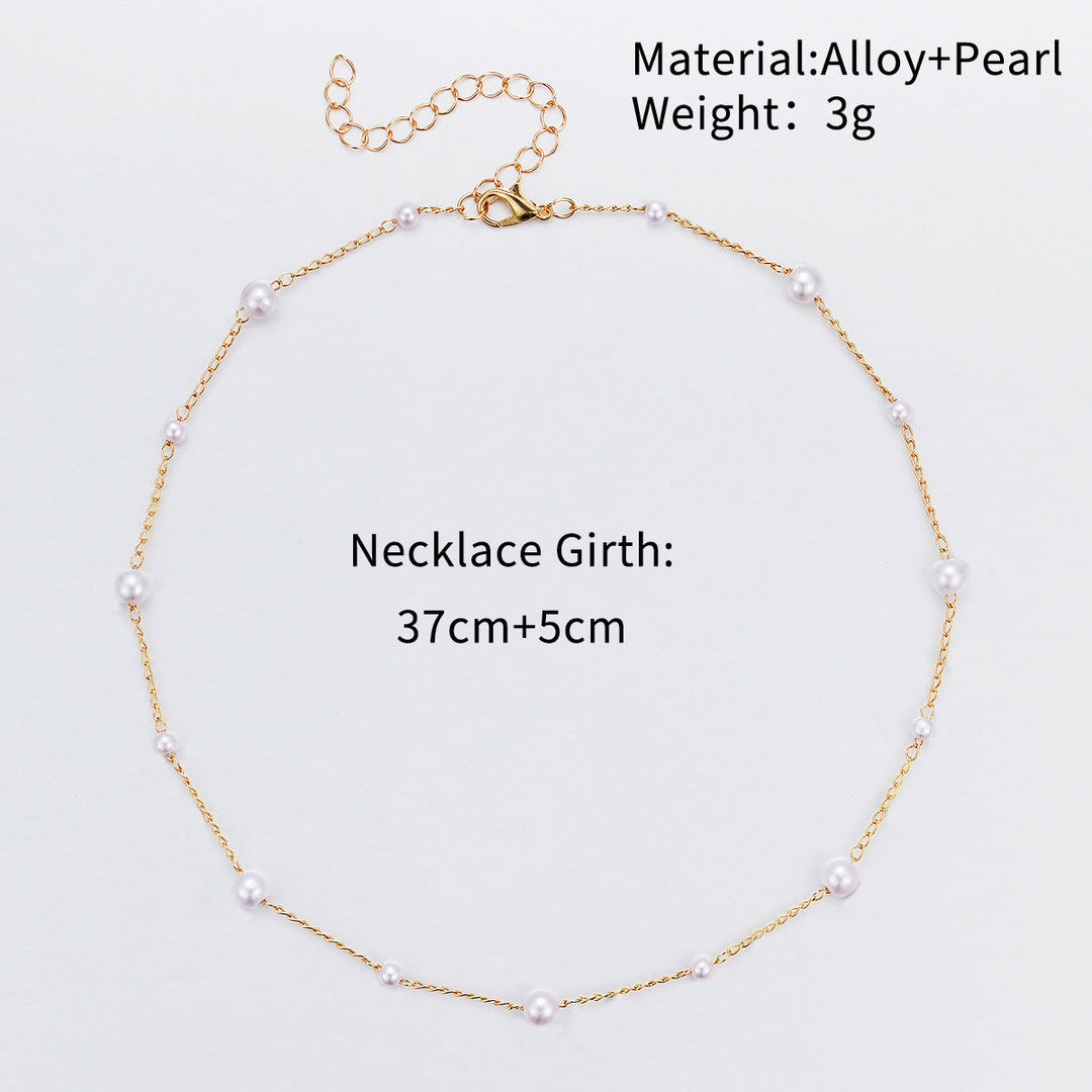Close-up of a delicate white pearl accented on a slender gold chain, elegant women's jewelry.