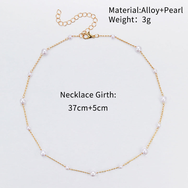 Close-up of a delicate white pearl accented on a slender gold chain, elegant women's jewelry.