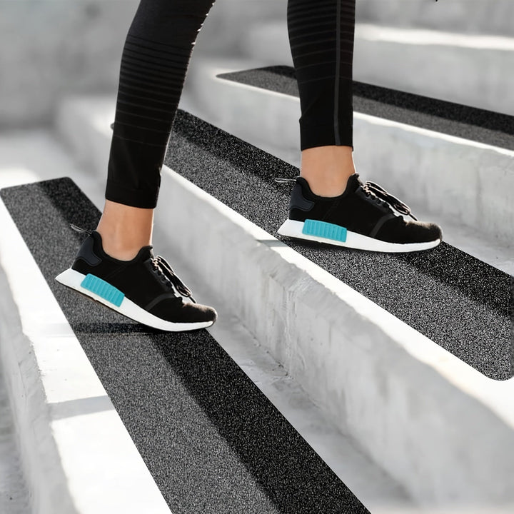 Black rubber non-slip tread strips for enhanced grip on stairs & driveways, increasing safety & preventing slips.