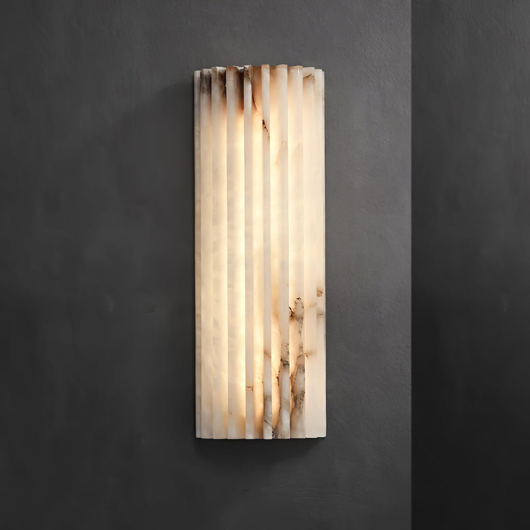 Smooth alabaster wall sconce, a modern LED lamp adding texture and elegant light to home interiors.