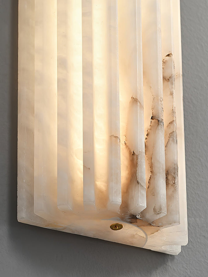 Side view of an elegant alabaster wall sconce, showcasing its slim profile and LED light.