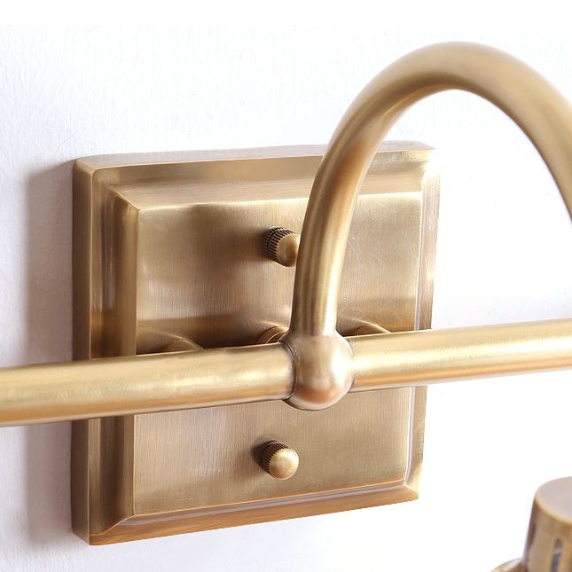 Antique brass wall sconce casting soft, diffused light, perfect for ambient home lighting.