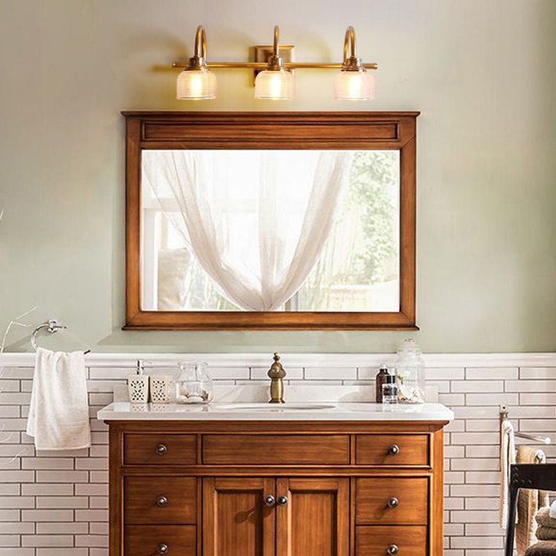 Elegant antique brass wall sconce, ideal bathroom vanity light with textured glass.