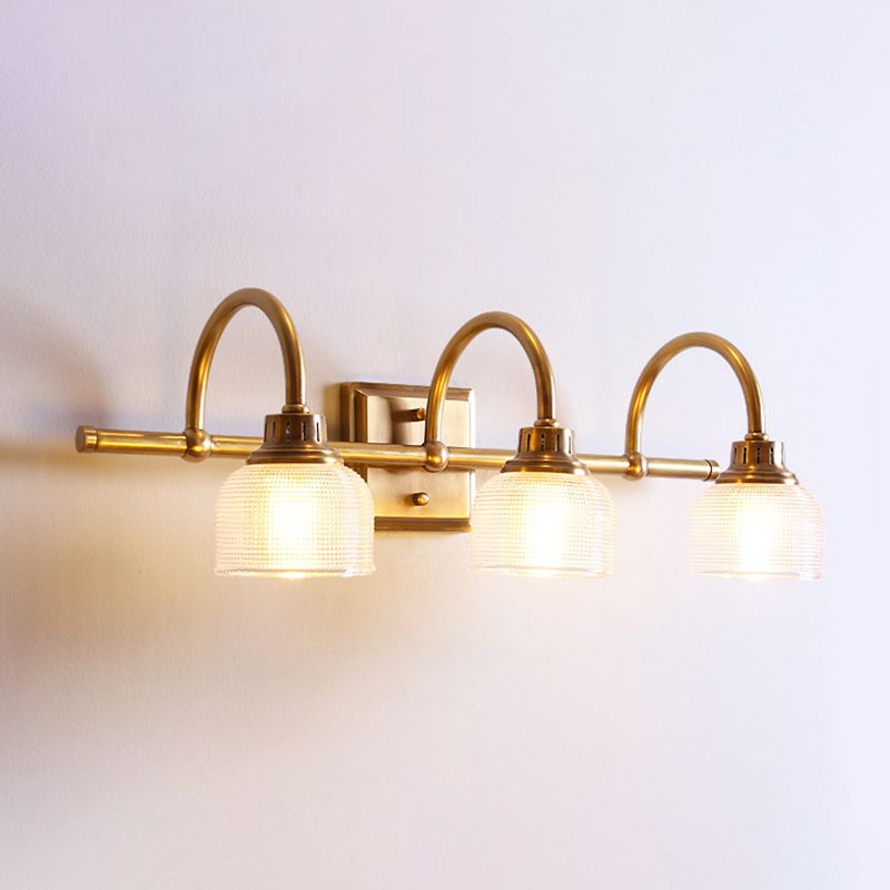 Decorative antique brass wall lamp provides warm bedroom lighting with diffused glow.