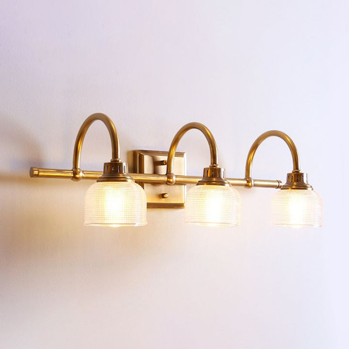 Decorative antique brass wall lamp provides warm bedroom lighting with diffused glow.