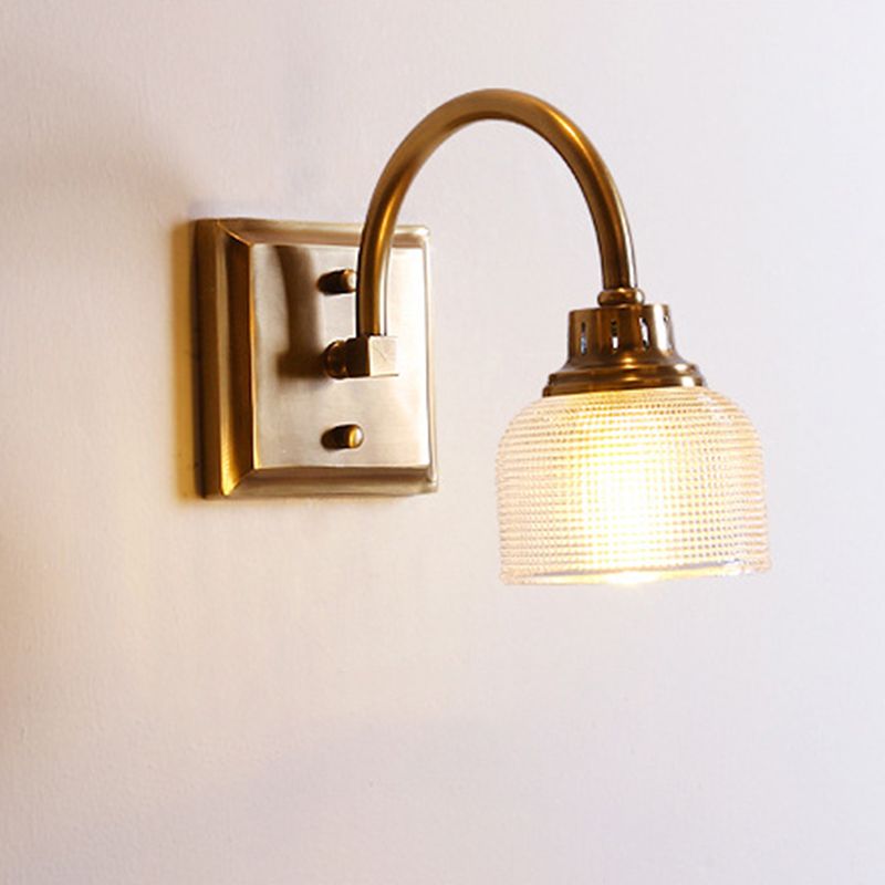 Hardwired antique brass wall sconce, an elegant indoor lamp providing diffused light.