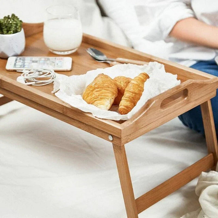 Stylish eco-friendly bamboo serving tray with foldable legs, ideal as a portable breakfast or lap table.