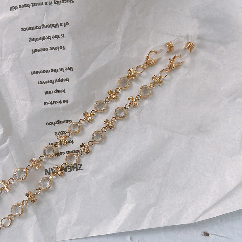 Fashionable women's eyewear holder with pearl-like beads & sparkling charms. A chic spectacle accessory.