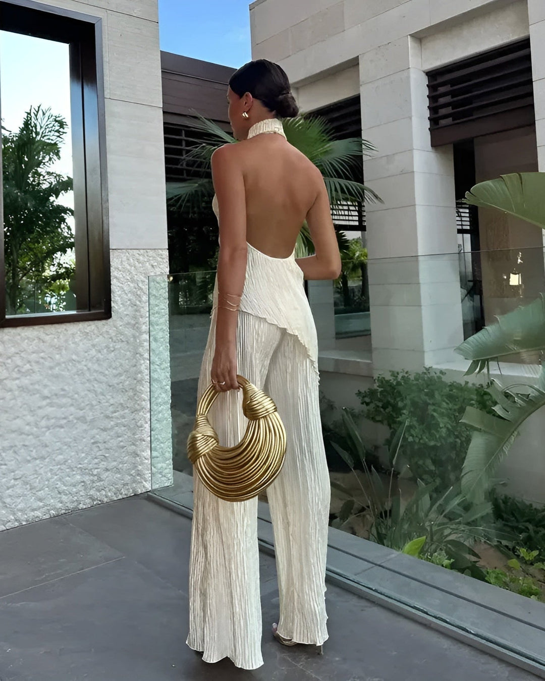 Fashionable women's beige asymmetrical backless jumpsuit, a versatile piece for elegant evening wear.