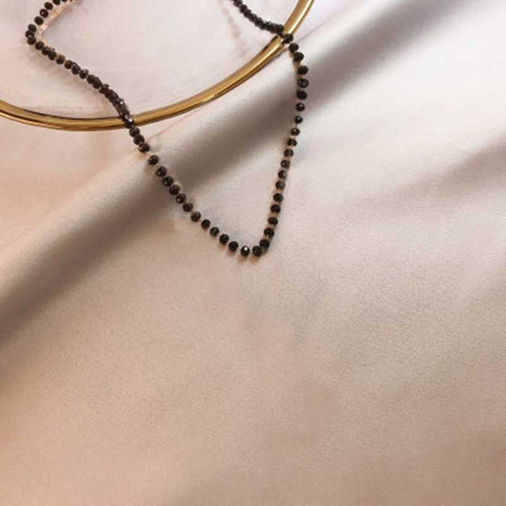 Close-up of a sleek black beaded choker, perfect minimalist jewelry for women's everyday style.