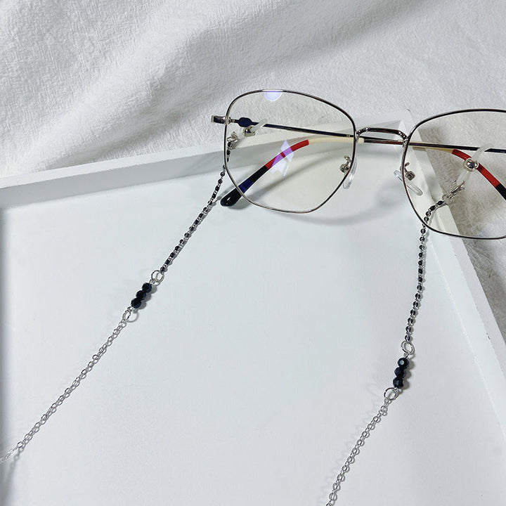 Secure eyeglass holder chain with elegant black pearls. Practical women's accessory for daily wear and style.